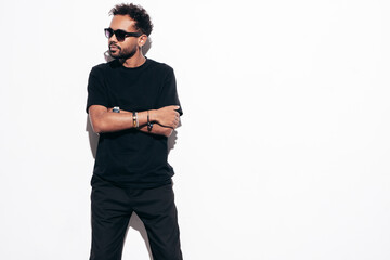 Handsome confident hipster model. Sexy unshaven man dressed in black  summer shirt and jeans...
