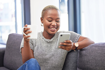 Woman, phone and relax on sofa with coffee for morning routine scroll social media. Happy African...