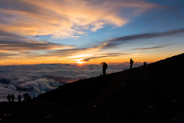 日の出と登山客のシルエット