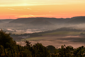 Bezaubernder Sonnenaufgang am frühen Morgen über Hammelburg mit Nebelschleier, Nebel liegt im Tal, Elfershausen bei Bad Kissingen, Franken, Bayern, Deutschland