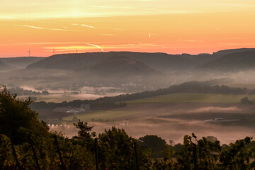 Bezaubernder Sonnenaufgang am frühen Morgen über Hammelburg, Nebel liegt im Tal, Elfershausen bei Bad Kissingen, Franken, Bayern, Deutschland