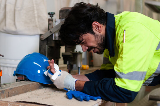 Engineer or worker man wearing uniform had a hand accident on machine in factory. Health and safety concept standards. Helpful and safety first.