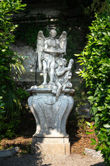 Fototapeta na wymiar Beautiful ancient sculptures in the botanical garden of the famous mediterranean Villa Monastero, located in traditional village of Varenna, Province of Lecco, on the shore of Lake Como, Italy.