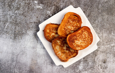 Cinnamon-Sugar Croutons on a white square  plate on a dark background. Top view, flat lay.