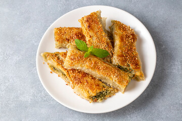 Greek cuisine dishes; spanakopita Sesame on handmade spinach feta cheese pie in the oven. Turkish name; ispanakli borek