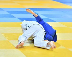 Fighter girls in judogi compete in judo on the tatami