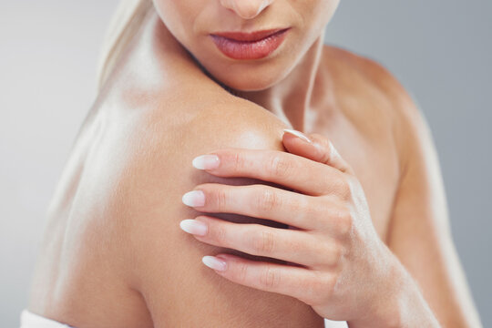 Beauty, body and zoom of a woman hand for self care and skincare on a grey studio background. Cosmetic, bodycare and skin care of a female arm or shoulder for health or wellness on a backdrop