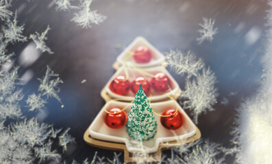 Fototapeta na wymiar Abstract Christmas background. Frozen postcard with decoration in the shape of a Christmas tree and balls.