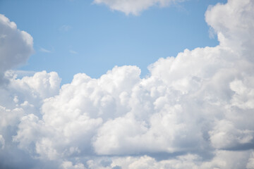 Naklejka na ściany i meble White large cumulus clouds in the blue sky.