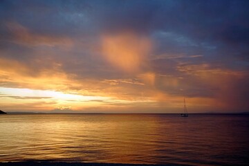 Horizontal shot. Empty beach in the evening at sunset. . Silhouettes and coastline. Sea bright sky. Greece Sithonia. Horizon. Clouds and rays of the sun. Bird island