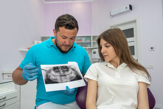 dentist doctor shows a picture of the jaw of a young patient.