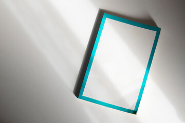 School notebook on a white background, spiral notepad on a table with unique shadow. flatlay