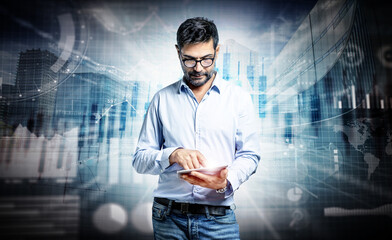 Focused finance manager wearing informal clothing and eyeglasses using a tablet in an abstract financial background with stock market graphs. - 544278863