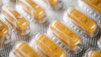 Yellow capsule in blister pack close up top view, dolly shot. Drug Production 