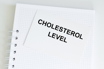 a white card with the text CHOLESTEROL LEVEL. Medical concept