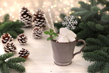 Hot chocolate with marshmallows. 
Fir tree branches with lights in the background.　マシュマロホットチョコレート　マシュマロホットココア