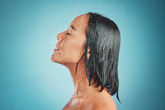 Woman, hygiene and wet shower for relax, beauty or fresh clean with water drops against a blue studio background. Relaxed female enjoying a hygienic wash and liquid sensation in cleanliness on mockup