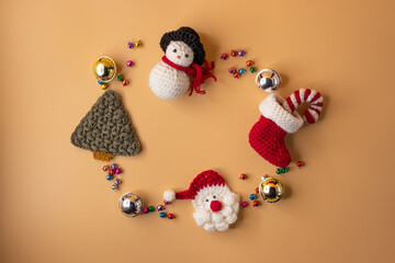 Handmade crochet stocking ,christmas tree, Candy canes, santa claus and gift on orange pastel background. Merry Christmas and happy new year concept.