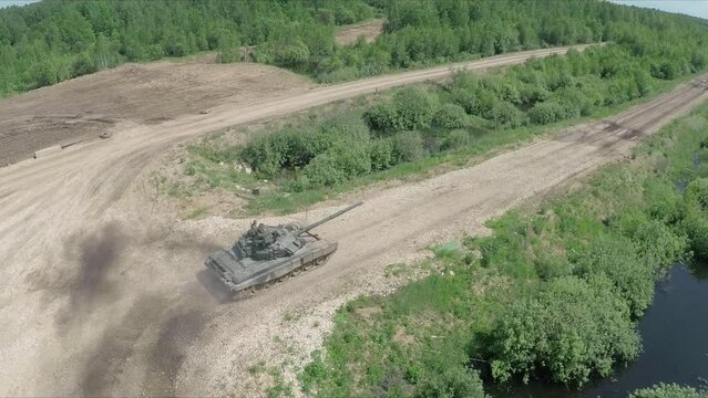 flying over tank driving on rough ground in the woods