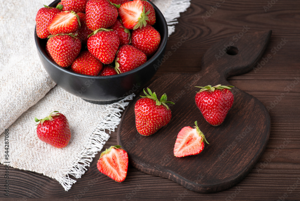 Canvas Prints Bowl of fresh red strawberries on black wooden table. Studio shot of strawberry