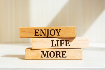 Wooden blocks with words 'Enjoy Life More'.