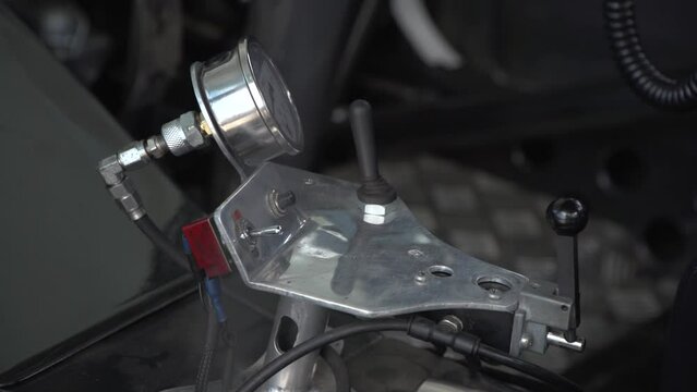 Close up of some steel dashboard near pilot seat inside the real drag racing car. Wires, switches and buttons seen also