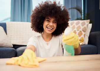 Happy, portrait and black woman cleaning dust on a table furniture with a cloth, liquid soap in a...