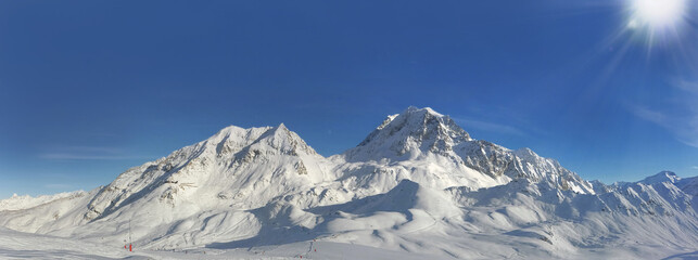 panoramic view on peak mountain covered with snow under sunny blue sky