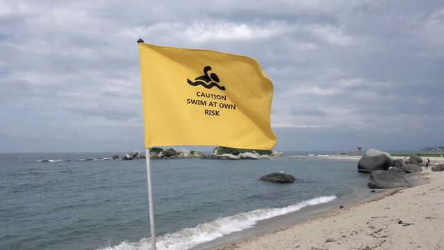 yellow flag indicates prohibition of bathing in the ocean sea, danger of swimming at your own risk in Caribbean Sea beach , Santa Marta Tayrona park Colombia