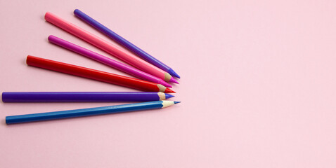 colored pencils showing a point on a pink background