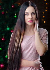 Portrait of beautiful girl near the Christmas tree. Beautiful long hair style. happy new year and Christmas concept. 