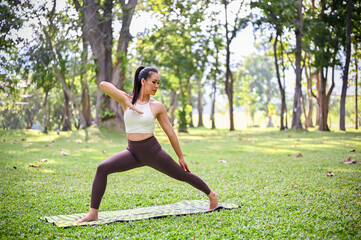 Fototapeta premium Healthy Asian woman in sportswear practicing Yoga pose, training yoga in the garden.