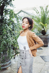 Young African American mixed race woman in park. Fall or spring season