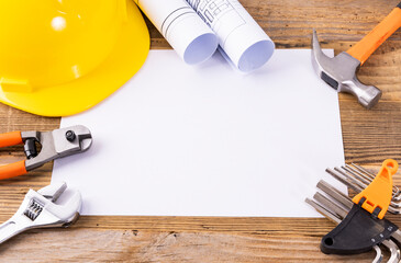 Hard hats and drawing tools on a wooden table