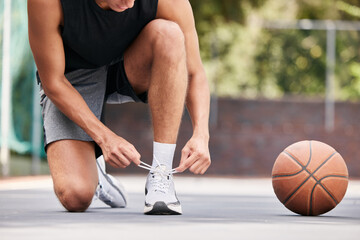Basketball, shoes and hands by man on the ground for lace before exercise, training and cardio at a...
