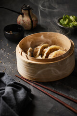 Steaming basket with gyoza with some steam coming off