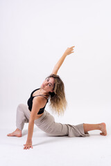 Fototapeta na wymiar Young dancer in studio photo session with a white background, ballet, stretching on the floor