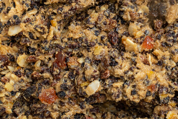 A big close-up of the ingredients of Christmas fruit cake in a large clay bowl. Top view