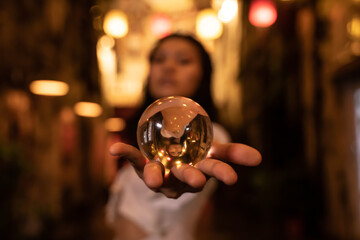 Asian woman holding a crystal ball in the street