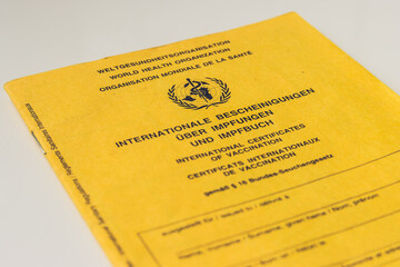 international vaccination certificate from the World Health Organization. Yellow vaccination book with in three languages. Cover sheet for WHO vaccination records