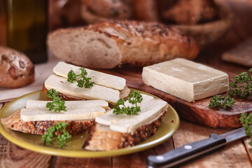 fresh cheese with bread - still life with served pastries and sliced cheese on a tray and chopping board