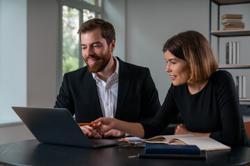 Smiling businesswoman and businessman in formal wear working together