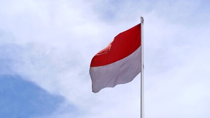 Indonesian national flag fluttering against the cloudy sky background