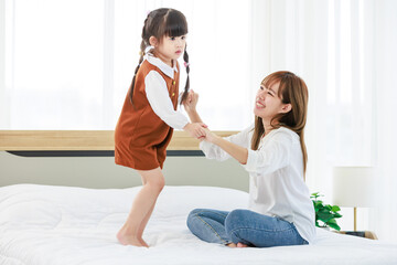 Millennial Asian happy cheerful little cute preschooler daughter girl standing dancing jumping on...
