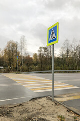  Yellow-white painted zebra and road sign of pedestrian crossing over road