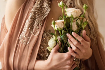 close up woman hands holding bunch of pale pink roses