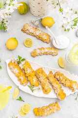 Traditional French dessert eclairs with lemon curd topping. Limoncello italian lemon liqueur,...