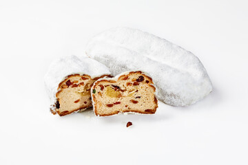 Whole and sliced mini marzipan stollens with nuts and dried fruit coated with powdered sugar