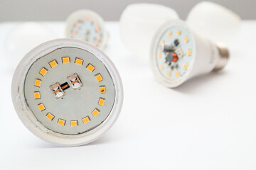 Disassembled LED lamp with one light emitting diode chip burnt out. Broken led bulb on a white....