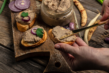 Woman hands spread bread with beans paste, Mexican cuisine pate of beans in glass jar. healthy vegetarian food, top view